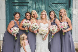 bride and bridesmaids in front of barn door