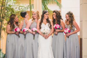bridesmaids in gray with pink bouquets