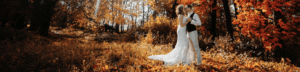 bride and groom walking in autumn leaves