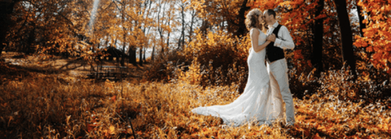 bride and groom walking in autumn leaves