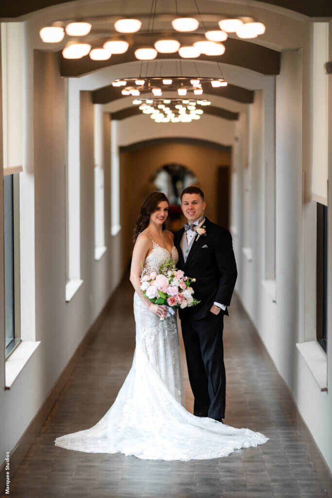 the bride and groom pose in the hallway