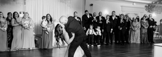 Groom dipping his bride and giving her a kiss on the dance floor