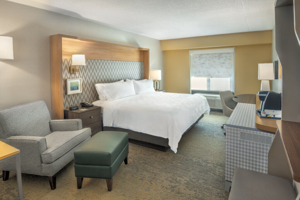 hotel room with modern furniture and king sized bed